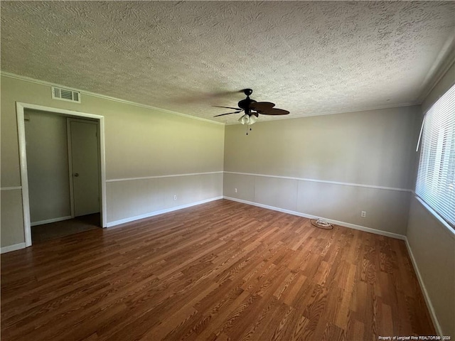 empty room featuring a textured ceiling, wood finished floors, visible vents, and ceiling fan