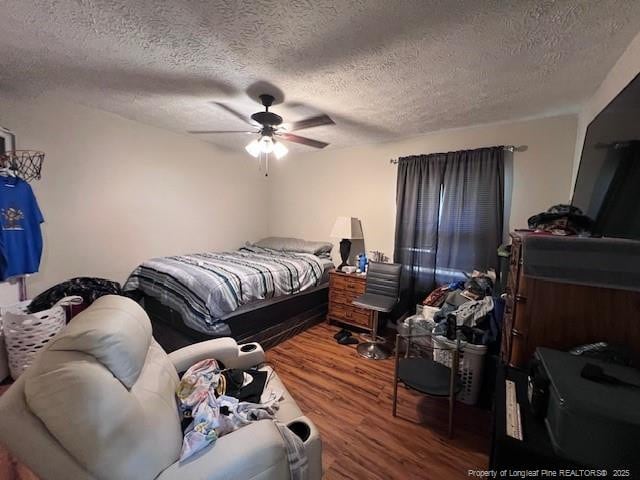 bedroom featuring wood finished floors, a textured ceiling, and a ceiling fan