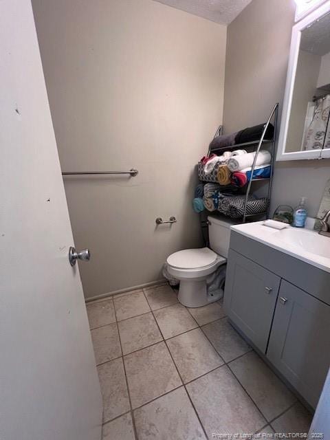 bathroom featuring vanity, toilet, and tile patterned flooring