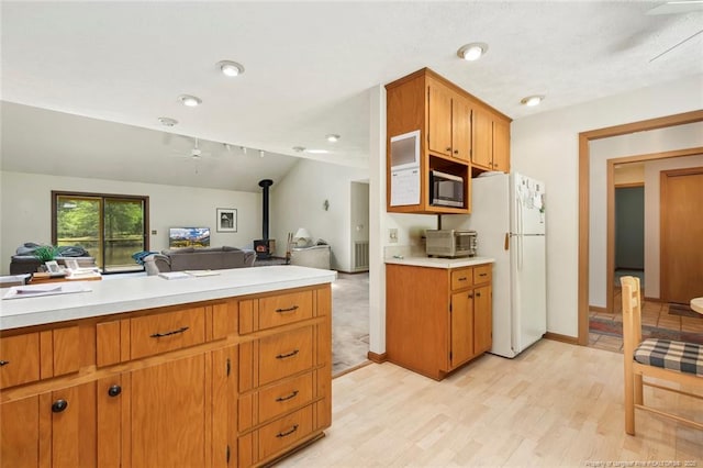 1619 Stonegate N, Sanford, NC 27332 - kitchen featuring stainless steel microwave, a wood stove, light countertops, and freestanding refrigerator