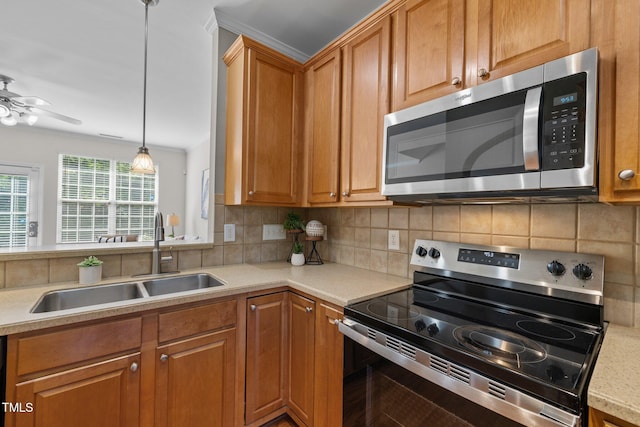 kitchen featuring appliances with stainless steel finishes, a sink, light countertops, backsplash, and ceiling fan