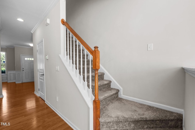 stairway with ornamental molding, wood finished floors, recessed lighting, and baseboards