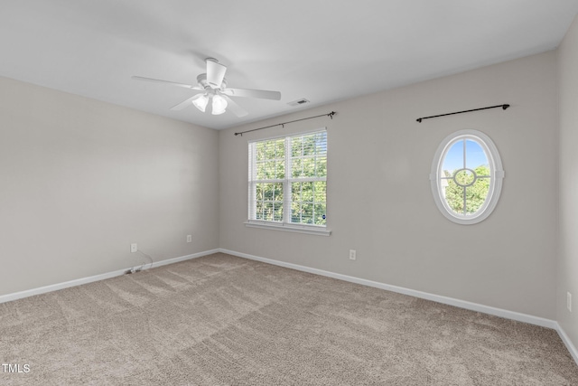 carpeted empty room with healthy amount of natural light, baseboards, and a ceiling fan