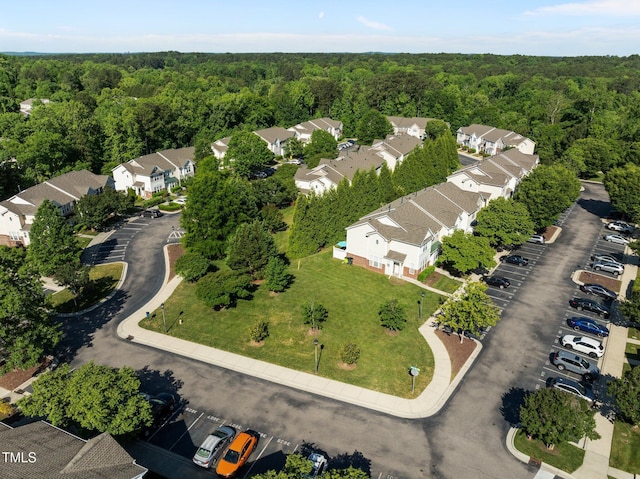 aerial view of property's location with a heavily wooded area and nearby suburban area