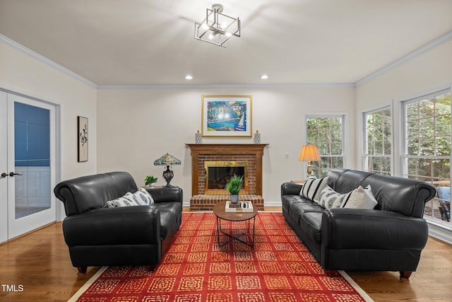 living area featuring ornamental molding, wood finished floors, recessed lighting, a brick fireplace, and baseboards