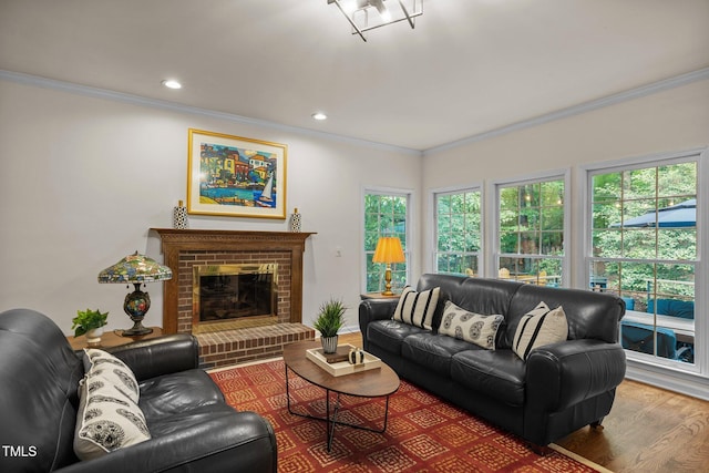 living room featuring ornamental molding, wood finished floors, a brick fireplace, and recessed lighting