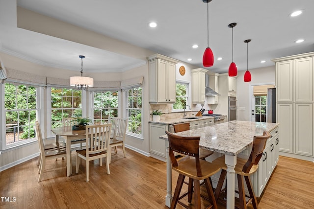 kitchen with a sink, stainless steel double oven, light stone counters, a center island, and recessed lighting