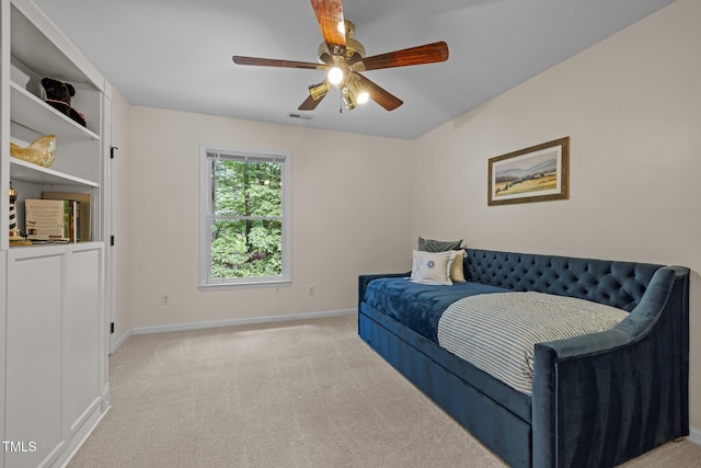 bedroom featuring light colored carpet, baseboards, and ceiling fan