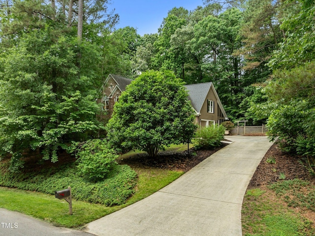 view of side of home featuring concrete driveway and fence