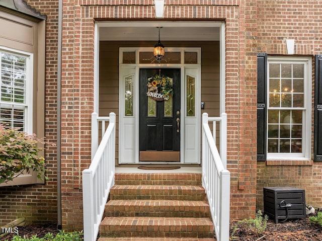 doorway to property featuring brick siding