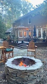 rear view of property with a fire pit