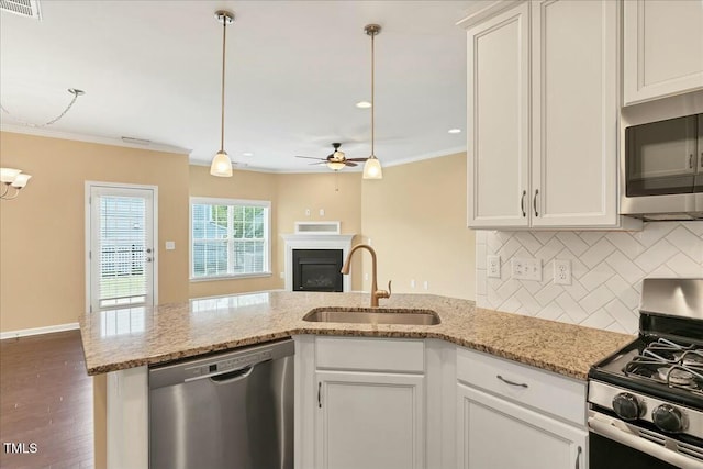 225 Gulley Glen Dr, Garner, NC 27529 - kitchen featuring a sink, stainless steel appliances, decorative backsplash, crown molding, and a peninsula