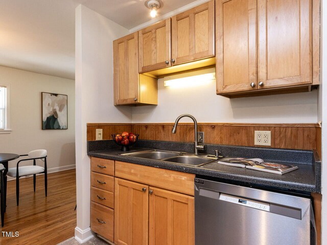 3818 Hillgrand Dr, Durham, NC 27705 - kitchen featuring stainless steel dishwasher, a sink, dark countertops, baseboards, and wood finished floors