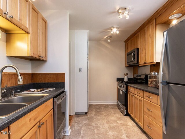 3818 Hillgrand Dr, Durham, NC 27705 - kitchen with dark countertops, baseboards, stainless steel appliances, and a sink