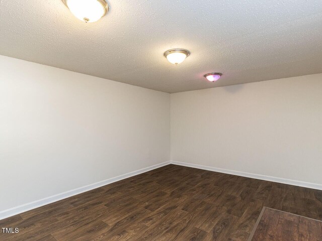 3818 Hillgrand Dr, Durham, NC 27705 - unfurnished room featuring baseboards, dark wood-type flooring, and a textured ceiling