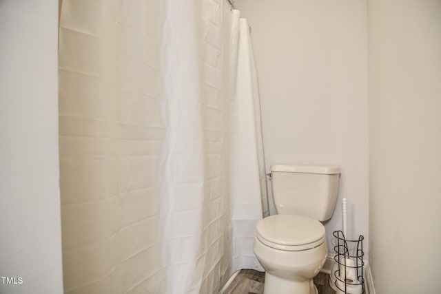 full bath with toilet, baseboards, and wood finished floors