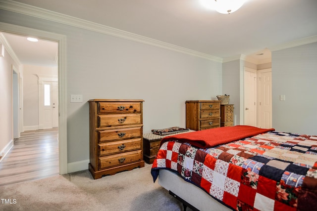 bedroom featuring crown molding, baseboards, and light carpet