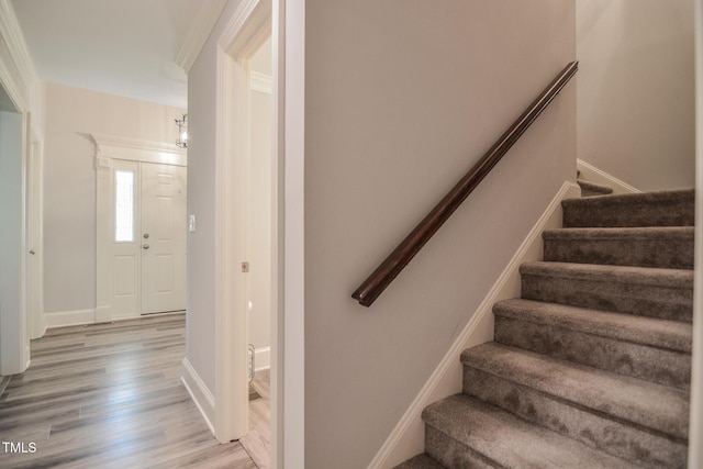 staircase with baseboards and wood finished floors