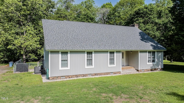 view of front of property featuring roof with shingles, central AC, a front yard, and crawl space
