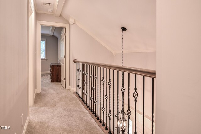 hall featuring visible vents, ornamental molding, baseboards, carpet flooring, and vaulted ceiling