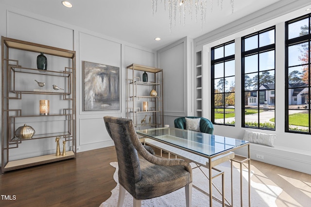 office space featuring wood finished floors, built in features, and a decorative wall