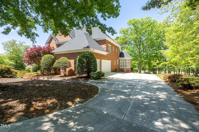 139 Stonebridge Dr, New London, NC 28127 - view of side of home with roof with shingles, concrete driveway, brick siding, and a garage