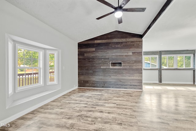 108 Carmichael Ln, Spring Lake, NC 28390 - unfurnished living room featuring wood finished floors, a wealth of natural light, vaulted ceiling, wood walls, and ceiling fan