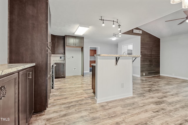 108 Carmichael Ln, Spring Lake, NC 28390 - kitchen featuring a breakfast bar area, light wood-style flooring, baseboards, dark brown cabinetry, and a ceiling fan