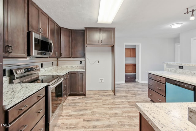 108 Carmichael Ln, Spring Lake, NC 28390 - kitchen with dark brown cabinetry, light stone counters, appliances with stainless steel finishes, baseboards, and light wood-type flooring