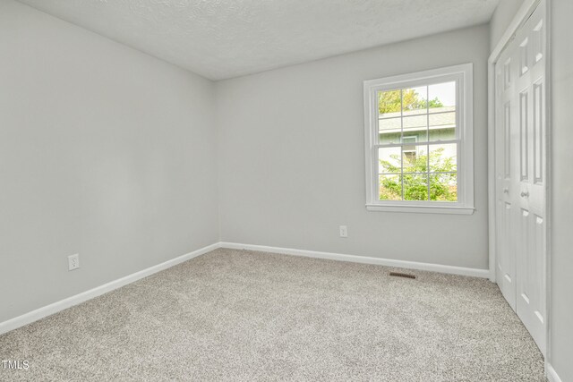 108 Carmichael Ln, Spring Lake, NC 28390 - carpeted empty room with a textured ceiling, visible vents, and baseboards