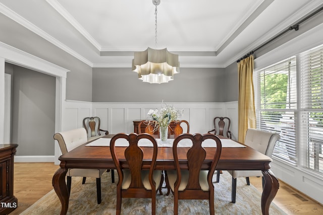925 Hidden Jewel Ln, Wake Forest, NC 27587 - dining room featuring a chandelier, healthy amount of natural light, light wood-type flooring, a tray ceiling, and a decorative wall