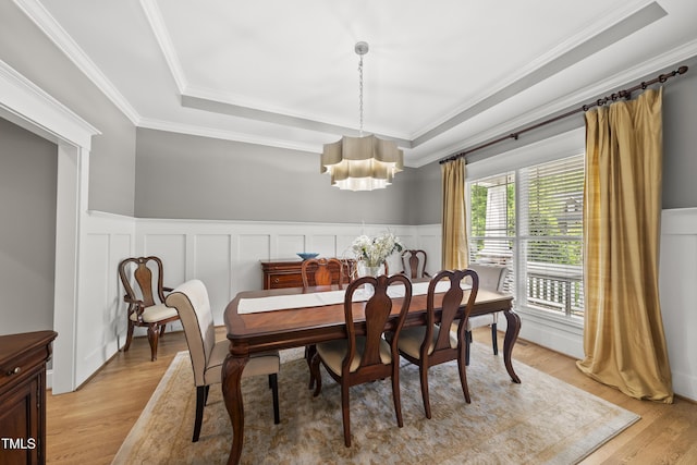 925 Hidden Jewel Ln, Wake Forest, NC 27587 - dining area featuring light wood-style flooring, ornamental molding, a tray ceiling, a chandelier, and a decorative wall