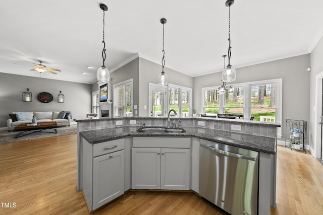 925 Hidden Jewel Ln, Wake Forest, NC 27587 - kitchen featuring dishwasher, a sink, open floor plan, light wood-type flooring, and dark stone counters