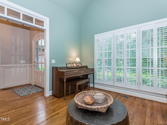 5401 Fire Pink Way, Raleigh, NC 27613 - living area featuring vaulted ceiling, wood finished floors, and a wainscoted wall