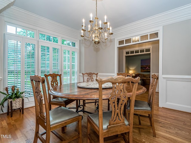 5401 Fire Pink Way, Raleigh, NC 27613 - dining space featuring ornamental molding, a chandelier, light wood-style flooring, a wainscoted wall, and a decorative wall