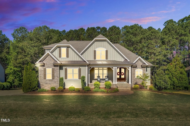 128 Paraggi Ct, Clayton, NC 27527 - craftsman house with stone siding, board and batten siding, a standing seam roof, covered porch, and a yard