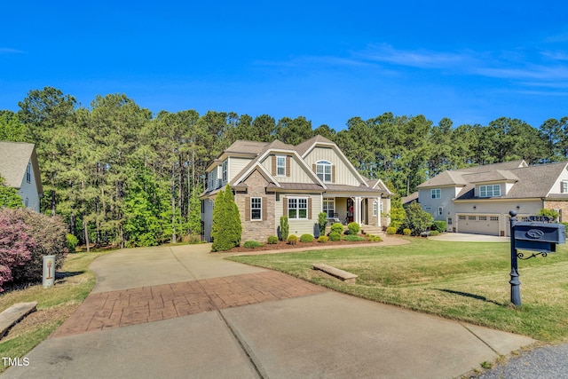 128 Paraggi Ct, Clayton, NC 27527 - view of front of property with board and batten siding, covered porch, driveway, a front lawn, and stone siding