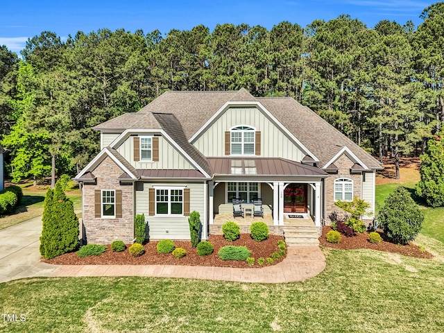 128 Paraggi Ct, Clayton, NC 27527 - craftsman-style house with board and batten siding, a standing seam roof, covered porch, and stone siding