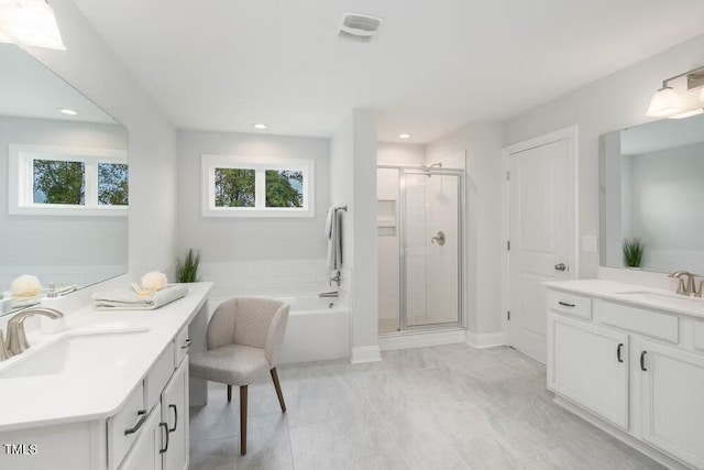 full bath with plenty of natural light, a stall shower, and a sink