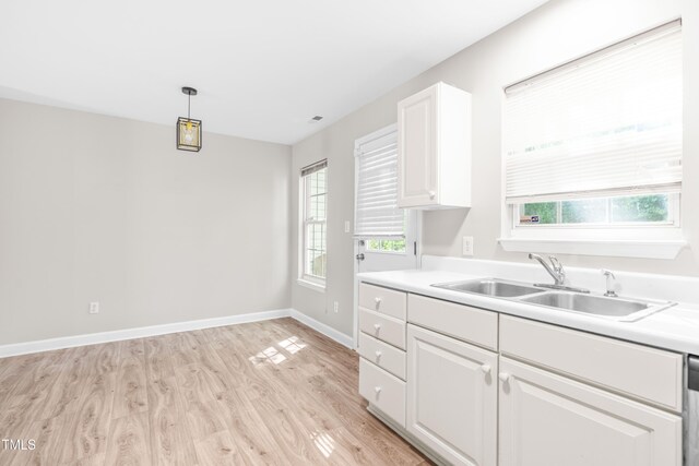 1628 Briarmont Ct, Raleigh, NC 27610 - kitchen with light wood finished floors, a sink, white cabinetry, and plenty of natural light