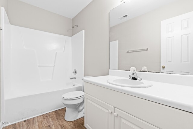 1628 Briarmont Ct, Raleigh, NC 27610 - bathroom featuring washtub / shower combination, vanity, toilet, visible vents, and wood finished floors