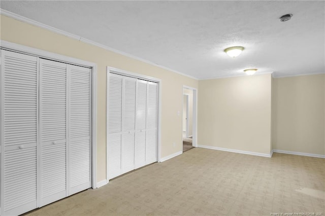 9701 Rockfish Rd, Fayetteville, NC 28376 - unfurnished bedroom featuring two closets, crown molding, baseboards, and light carpet