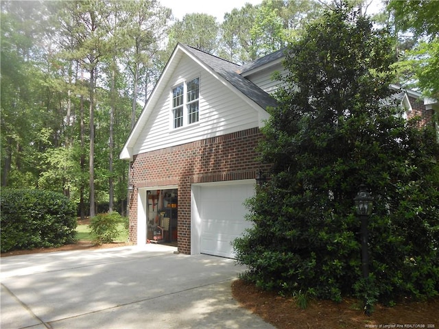 600 Yorkshire Pl, Lumberton, NC 28358 - view of property exterior with an attached garage, driveway, brick siding, and roof with shingles