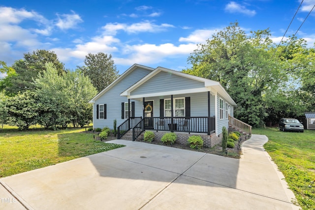 bungalow-style home featuring covered porch and a front yard