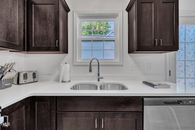 kitchen with light countertops, dark brown cabinetry, a sink, and dishwasher