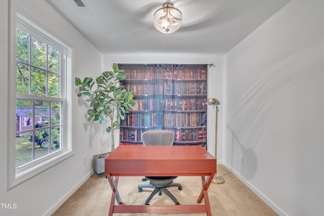 office space featuring carpet floors, baseboards, and visible vents