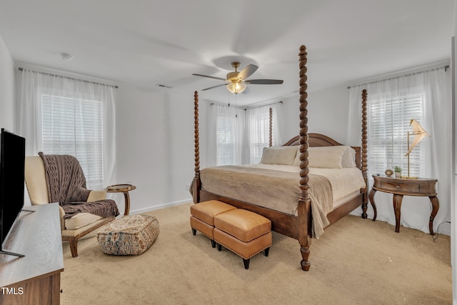 bedroom featuring ceiling fan, multiple windows, visible vents, and light colored carpet