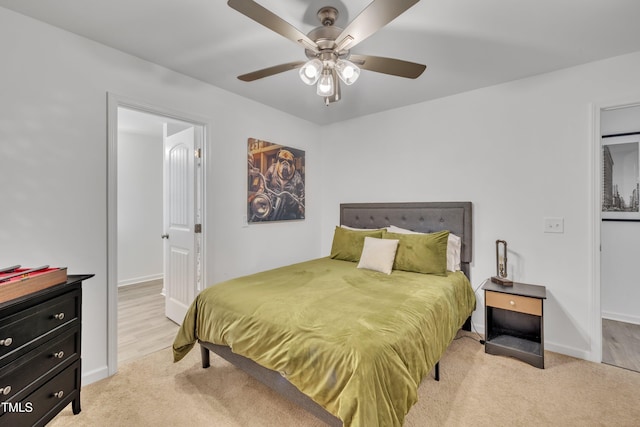 bedroom featuring baseboards, ceiling fan, and light carpet