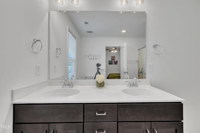 bathroom with a sink, ceiling fan, double vanity, and visible vents