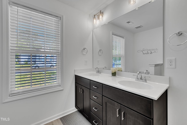 full bathroom featuring double vanity, a sink, and visible vents